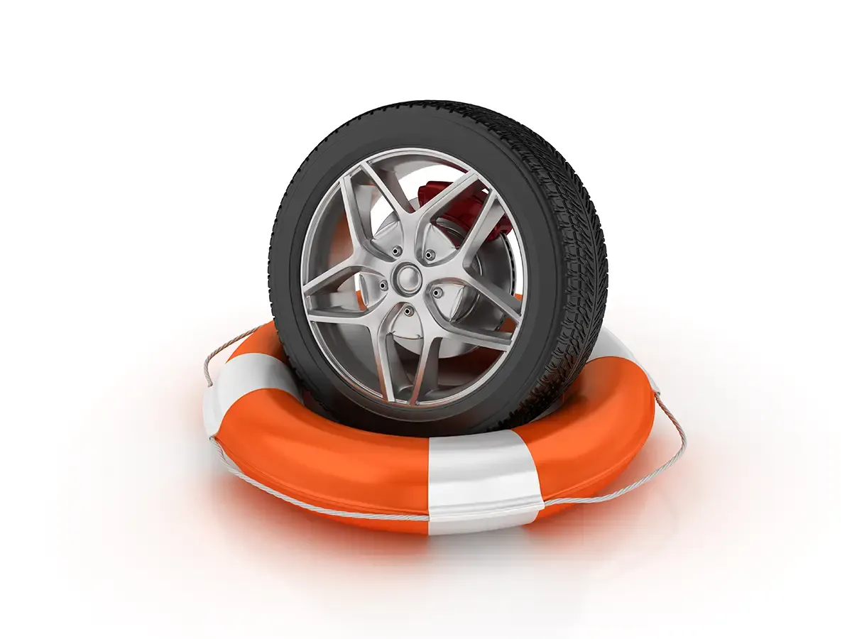 Autorad mit Felge steht auf einem orange-weißen Rettungsring vor weißem Hintergrund.
