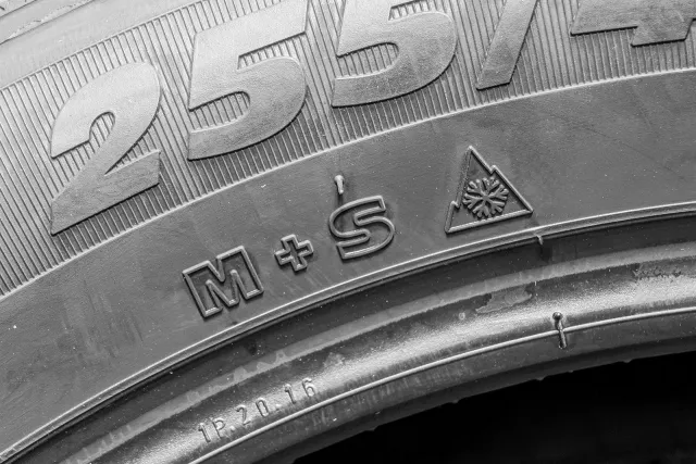 Reifenkennzeichnung M+S und Schneeflocke auf der Seitenwand eines Autoreifens