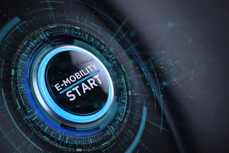 Startknopf mit Aufschrift „E-MOBILITY START“ und leuchtender Dititalgrafik